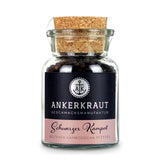 Schwarzer Kampot Pfeffer von Ankerkraut im Korkenglas auf weißem Hintergrund.